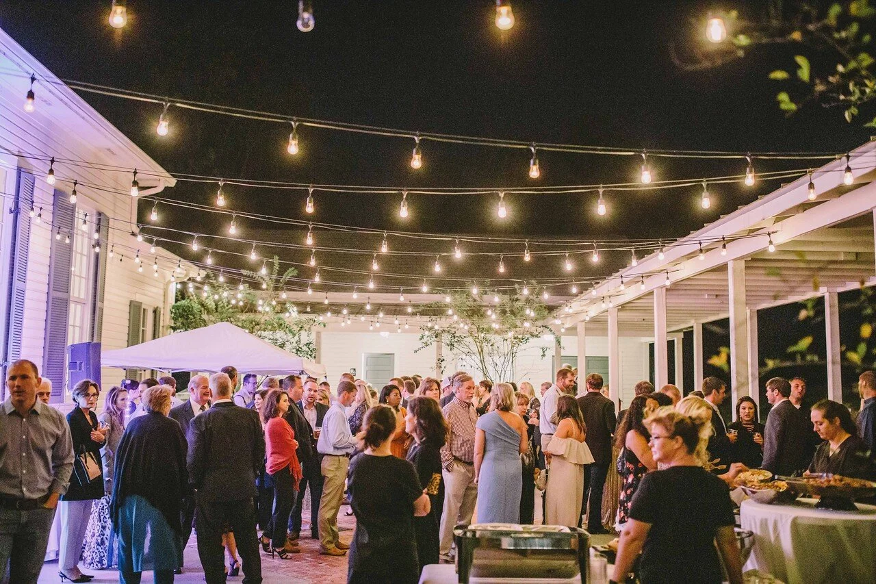Guests gathering beneath a canopy of lights at an OAK experience