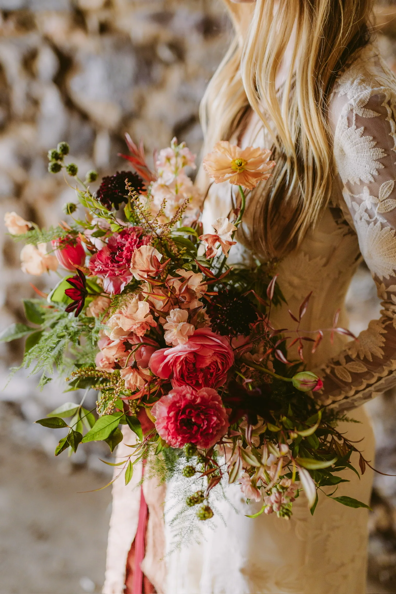 Close view of a coral and burgundy bridal bouquet